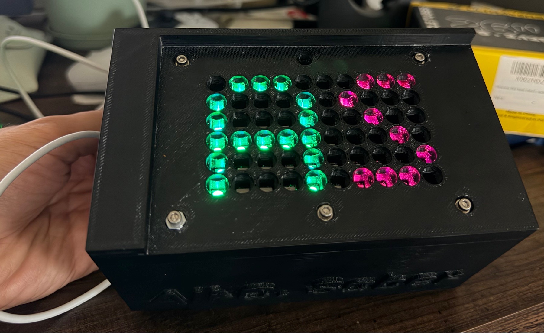 Black 3D-printed plate tracker without the laboratory plate, exposing the six-by-ten LED array